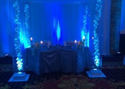 Acrylic Chuppah Signature Grand Sweetheart Table with Acrylic Chuppah with Silk Orchid and Blue uplights re-positioned after ceremony